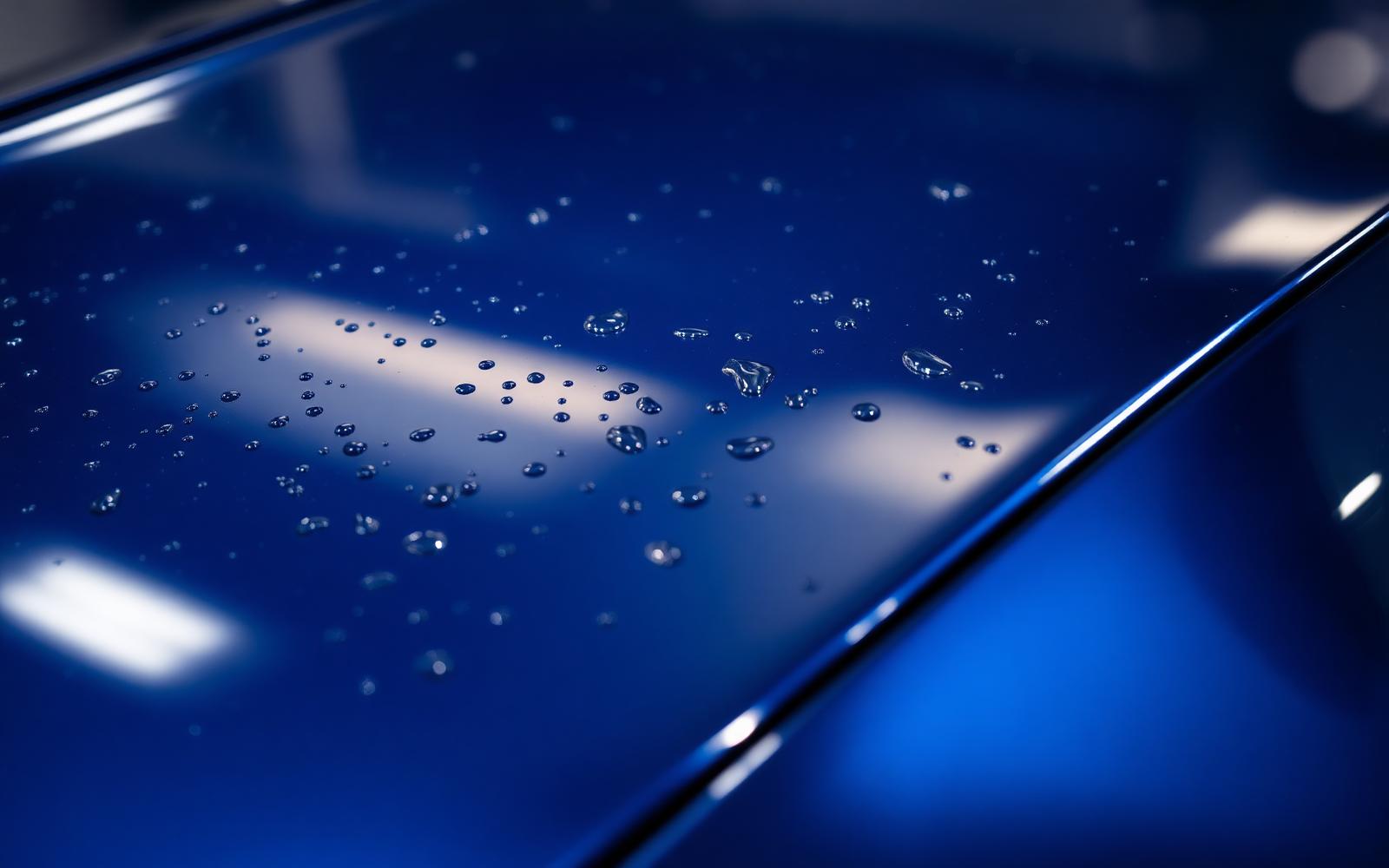 Detailed glossy blue car finish with water beads